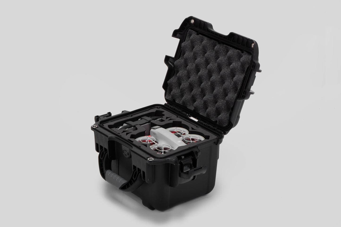 Angled view of DJI Neo Black Color Adventure Ready Compact Waterproof Carry-on Case and Custom Foam Insert with a Red Layer, holding the DJI Neo Combo
