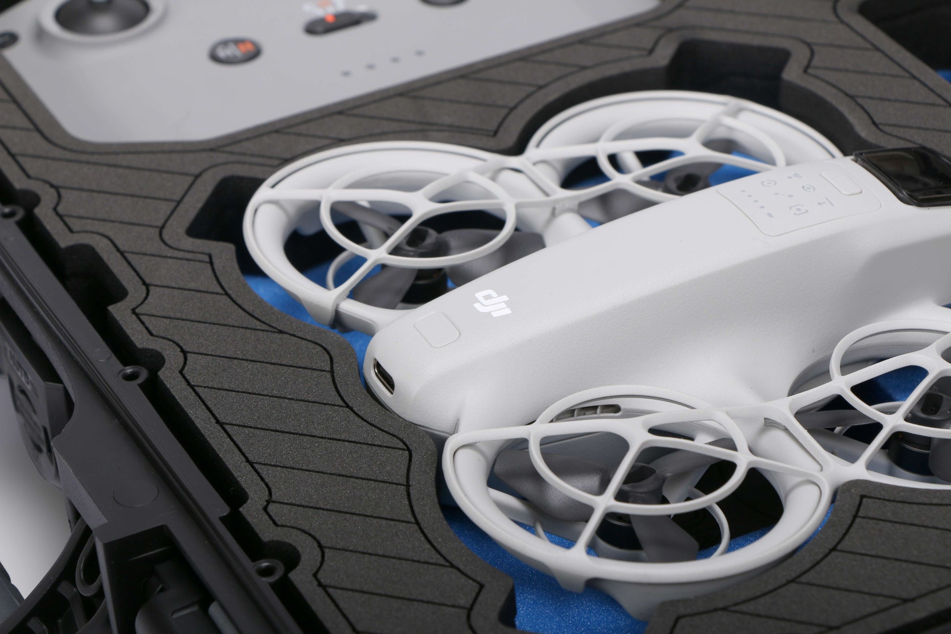 Close up view 1 of Foama black all-weather carry-on case with stylish blue layer insert, holding DJI Neo