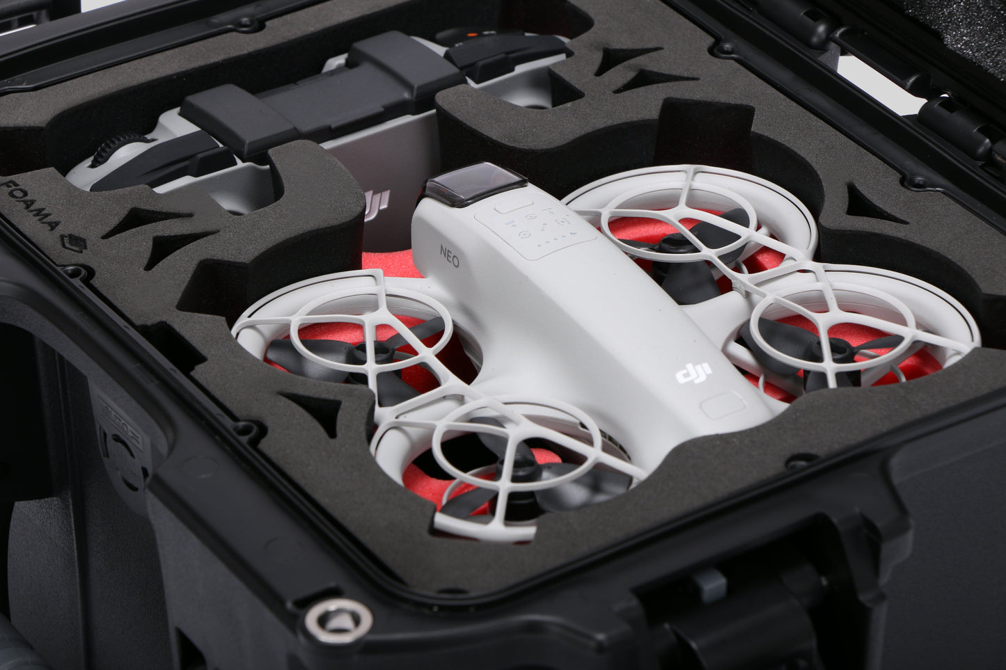 Close-up view 1 of DJI Neo Black Color Adventure Ready Compact Waterproof Carry-on Case and Custom Foam Insert with a Red Layer, holding the DJI Neo Combo