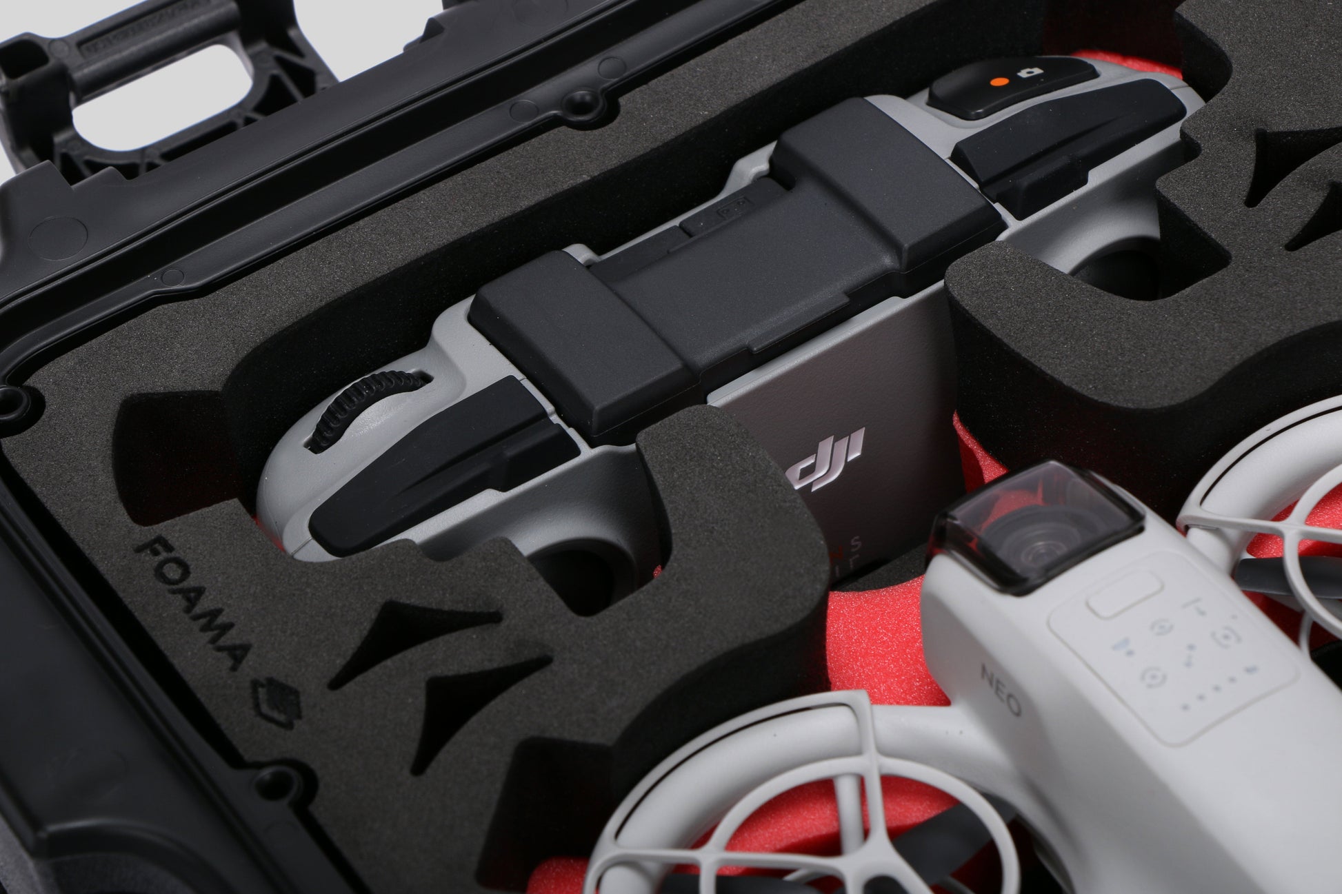 Close-up view 2 of DJI Neo Black Color Adventure Ready Compact Waterproof Carry-on Case and Custom Foam Insert with a Red Layer, holding the DJI Neo Combo
